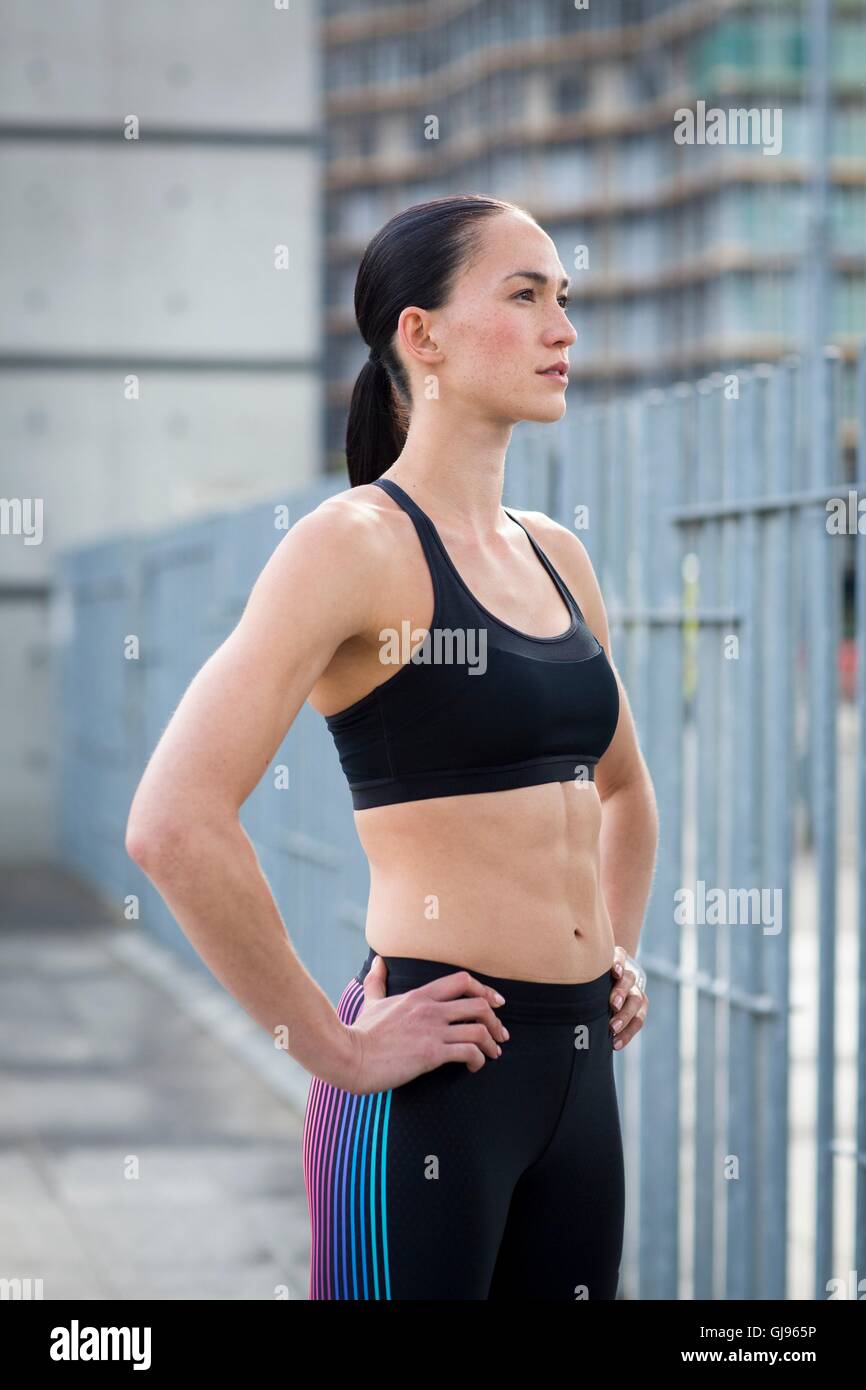 MODEL RELEASED. Young woman in crop top with hands on hips. Stock Photo