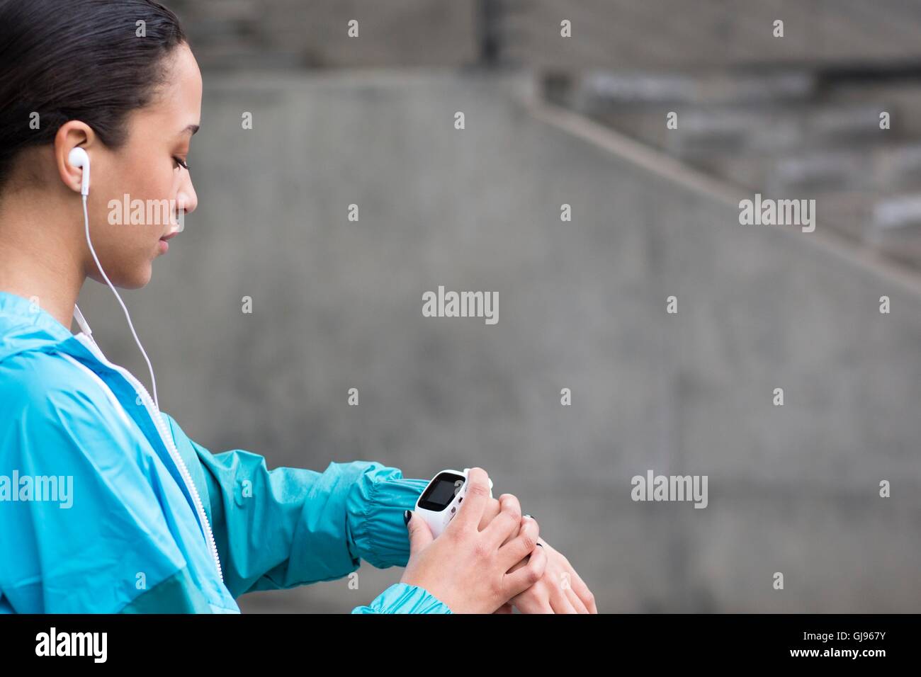 MODEL RELEASED. Young woman checking watch. Stock Photo