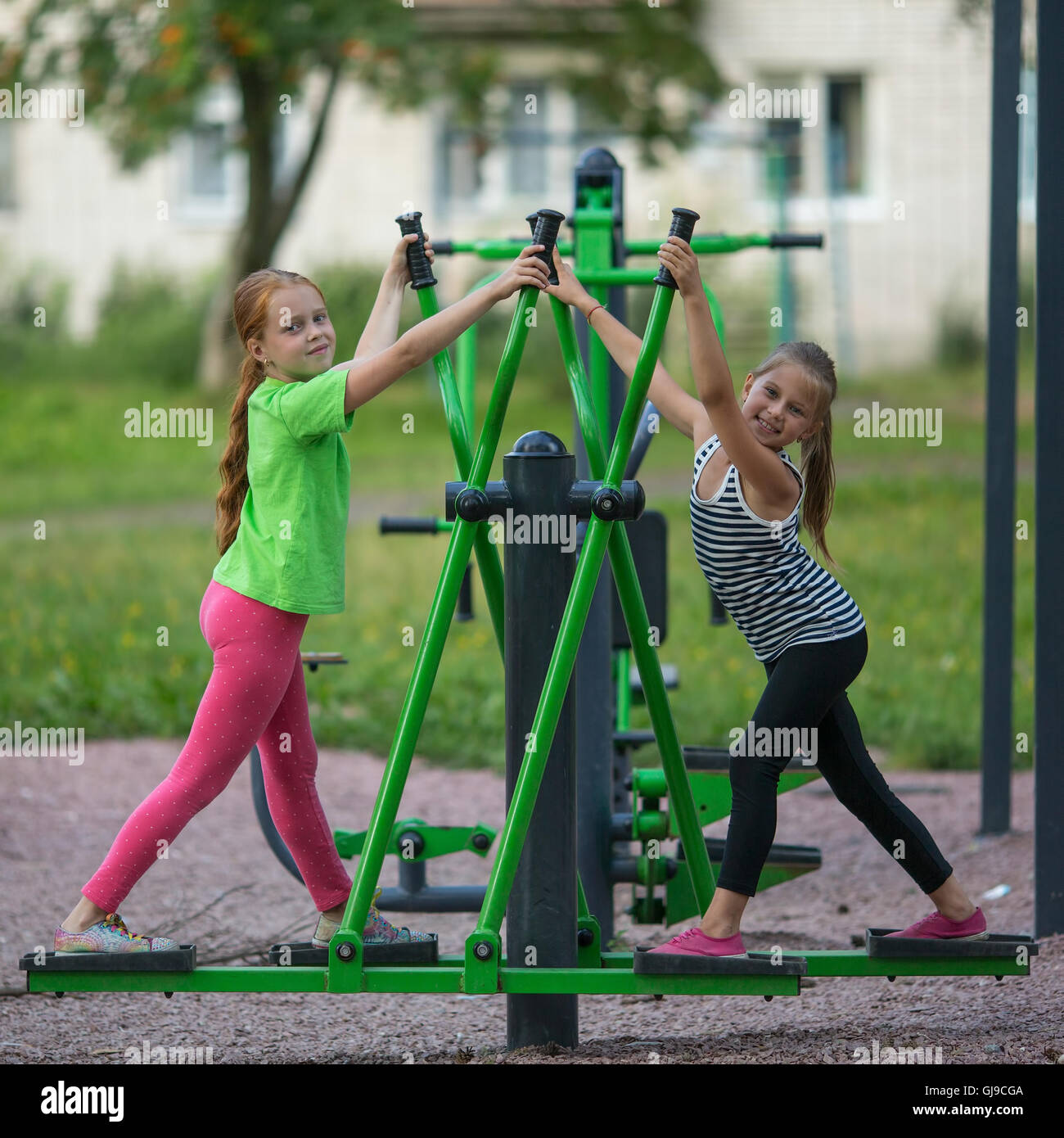 Kids girls practice gymnastics on the public sport equipment outdoors Stock Photo Alamy