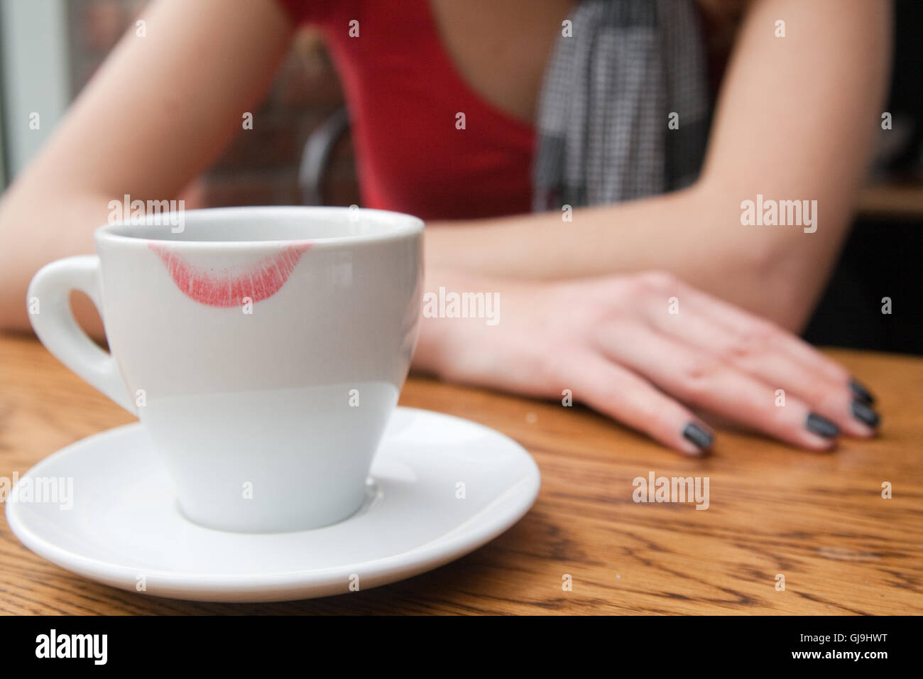 The girl is drinking coffee with a white cup with traces of lipstick Stock Photo