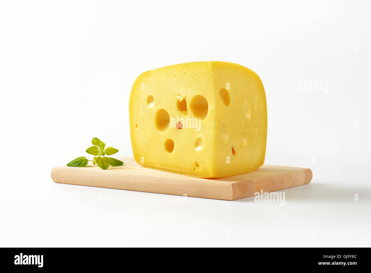 wedge of fresh cheese on wooden cutting board Stock Photo