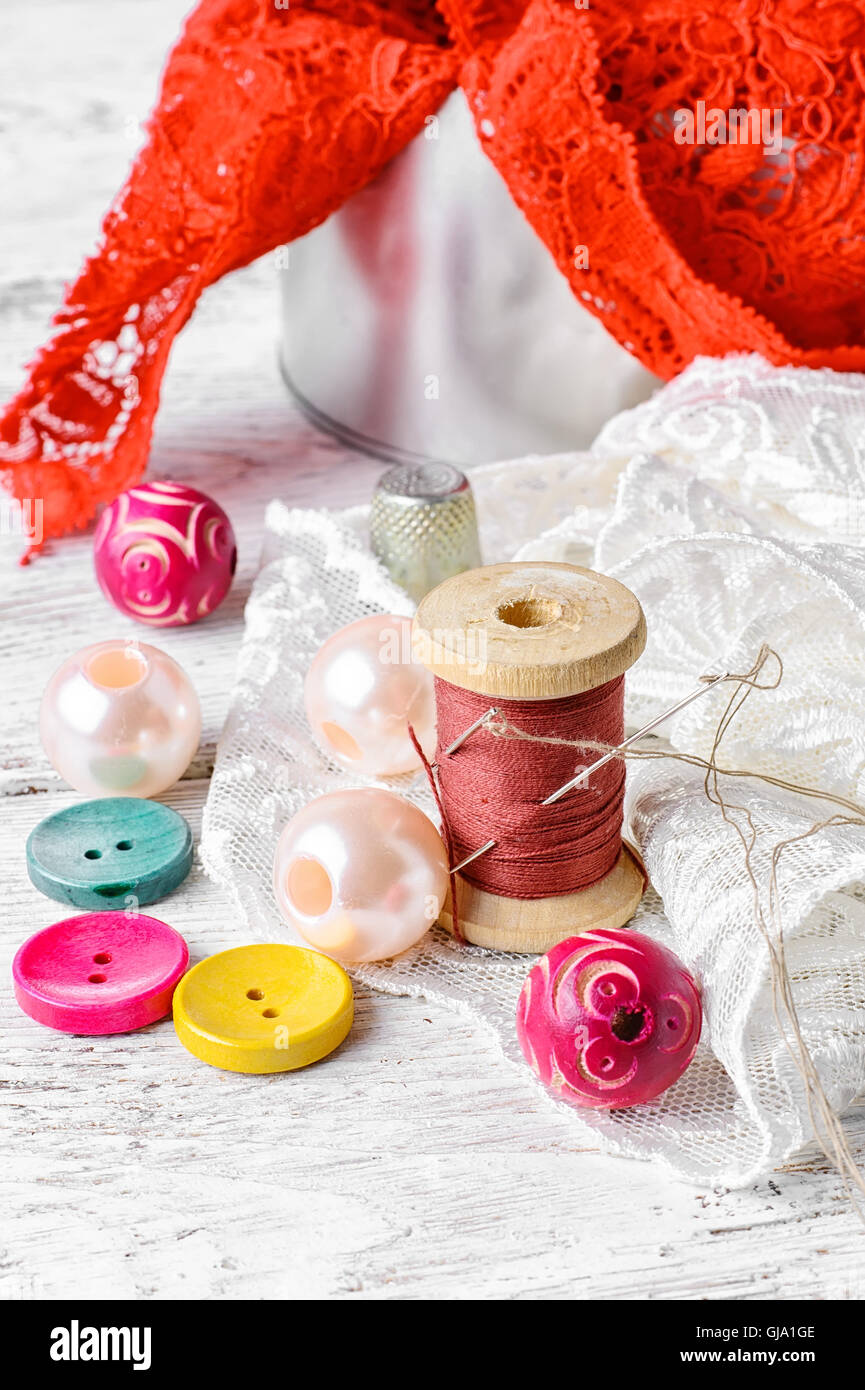Fabric lace,bright colored buttons and thread on a light background ...
