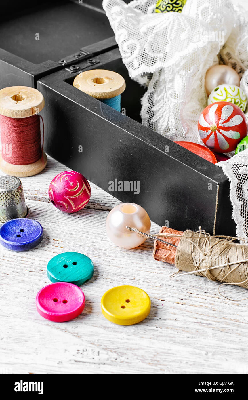 Fabric lace,bright colored buttons and thread on a light background ...
