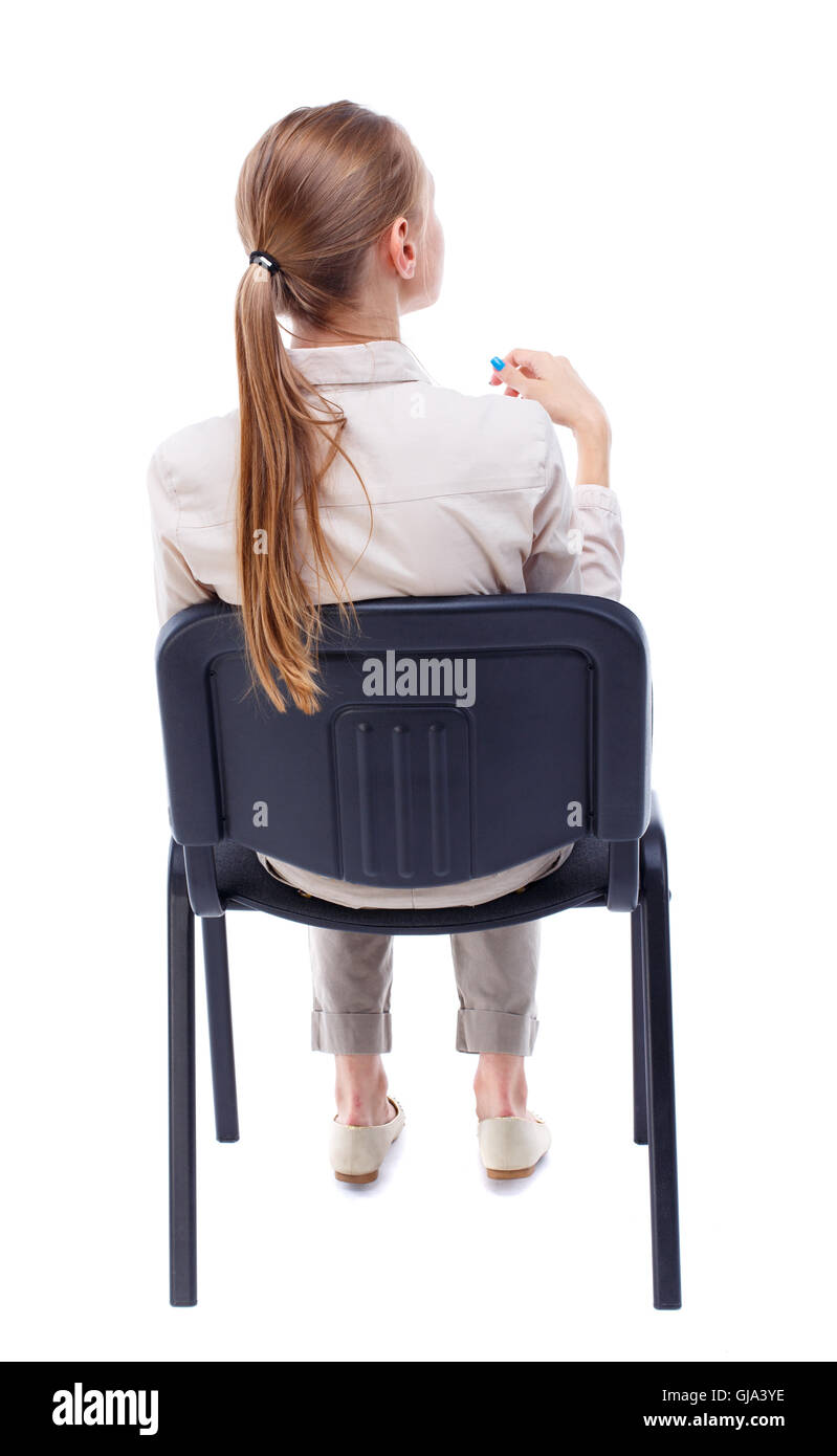 back view of young beautiful  woman sitting on chair. Stock Photo