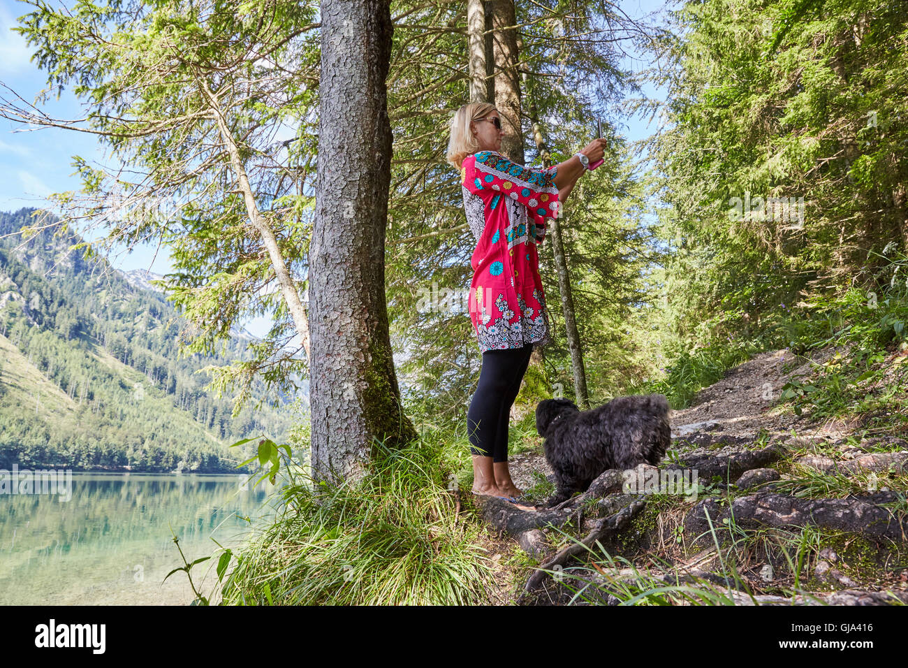 Woman taking a selfie photo of lake Vorder Langbathsee in Austria ...