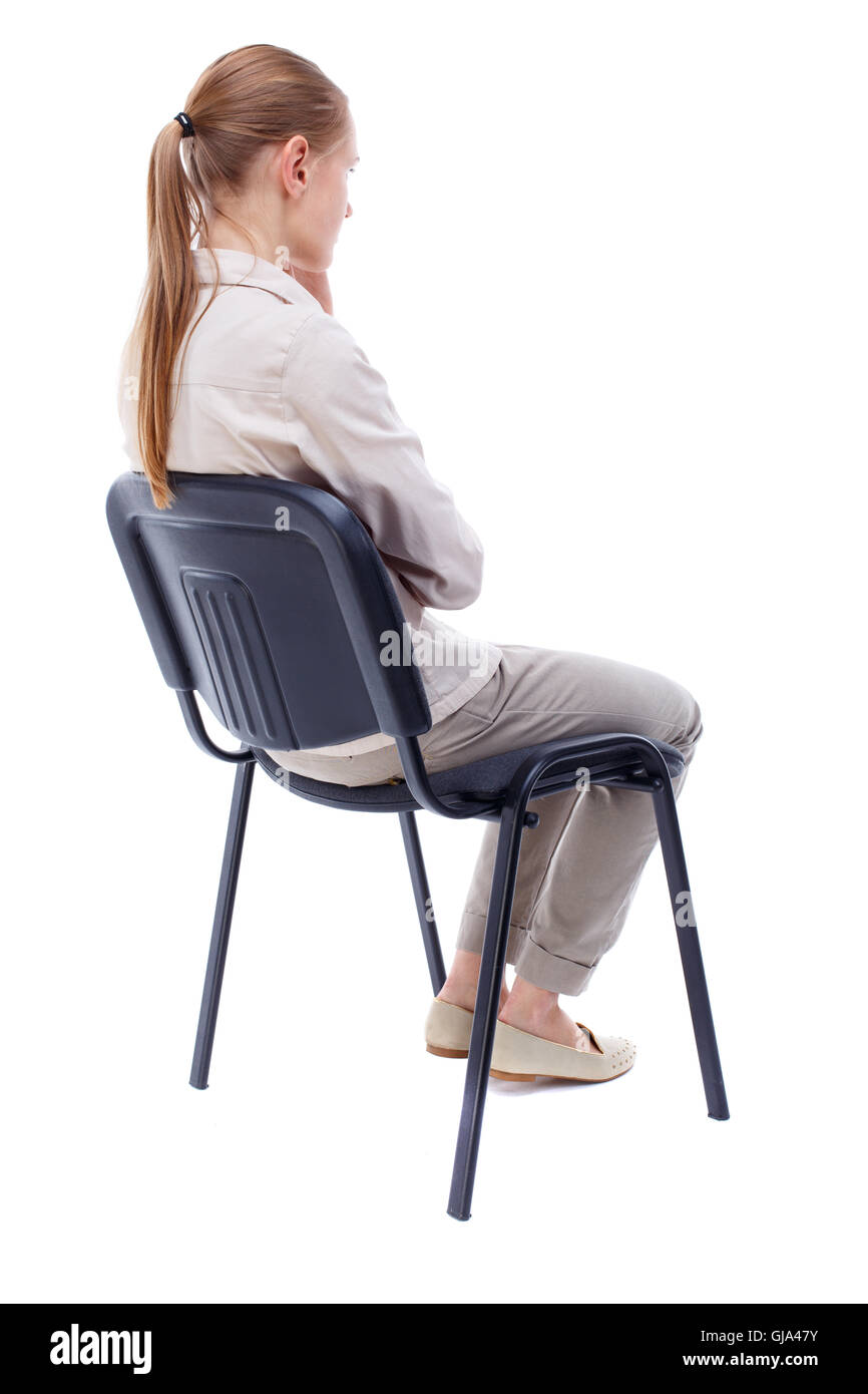 back view of young beautiful  woman sitting on chair. Stock Photo