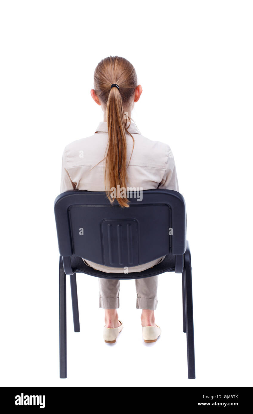 back view of young beautiful  woman sitting on chair. Stock Photo