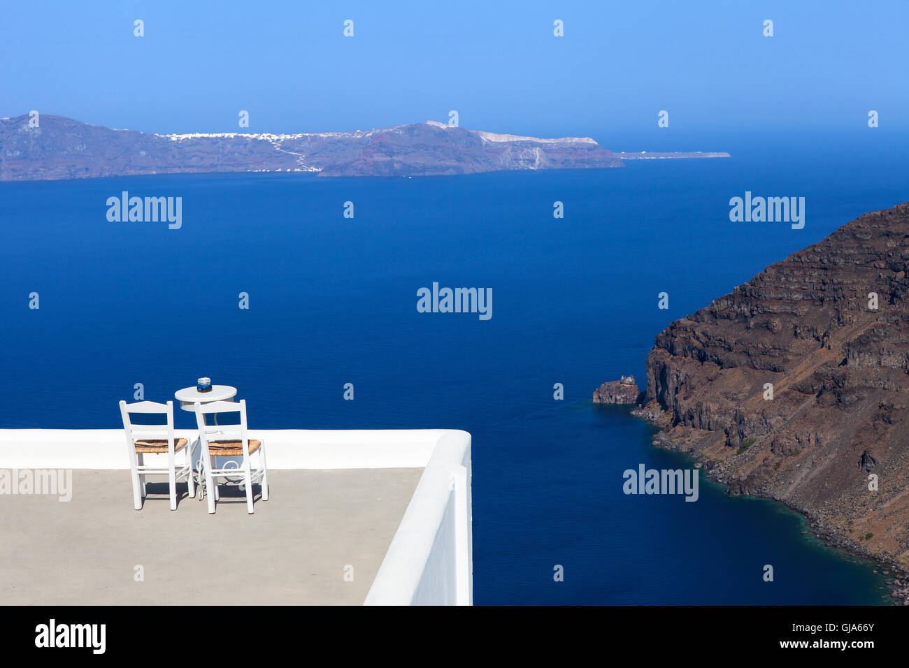 White houses of Fira, Santorini with Santorini's famous volcano in the background Stock Photo