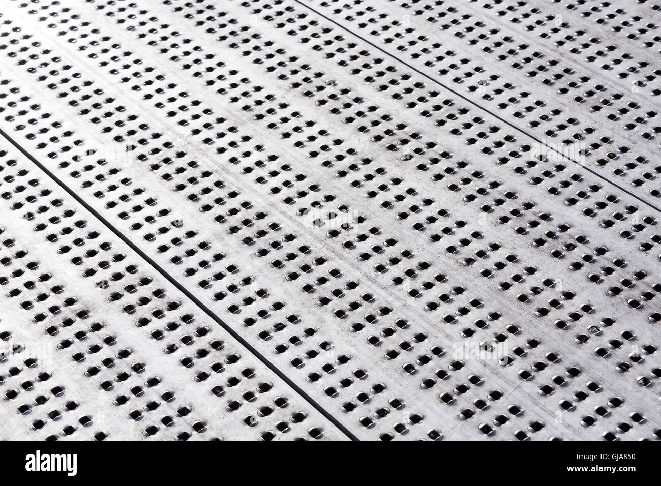 Scratched industrial metal floor surface with holes Stock Photo