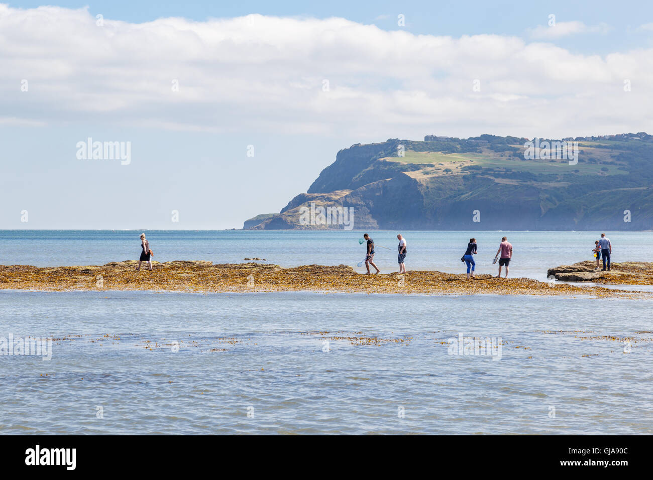 Various people on beach, fishing and crabbing. In Robin Hoods Bay, North Yorkshire Stock Photo