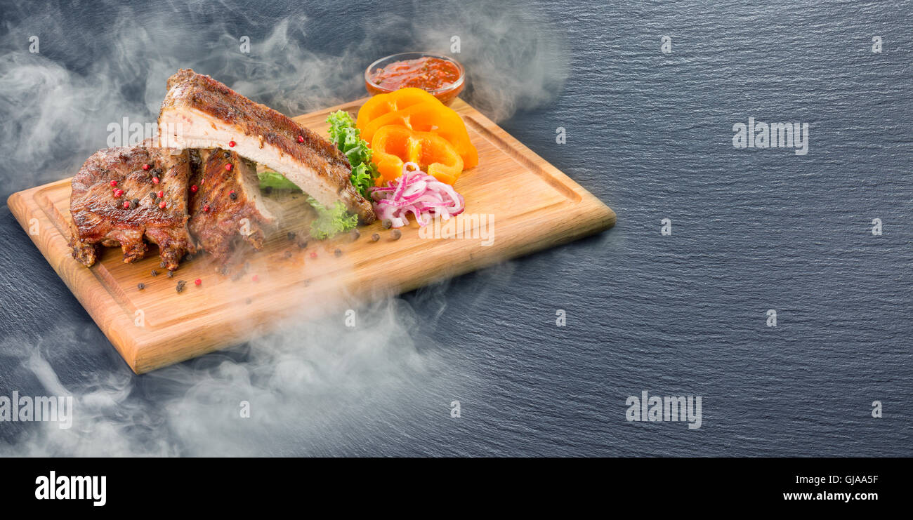 grill ribs with smoke on slate table. Stock Photo