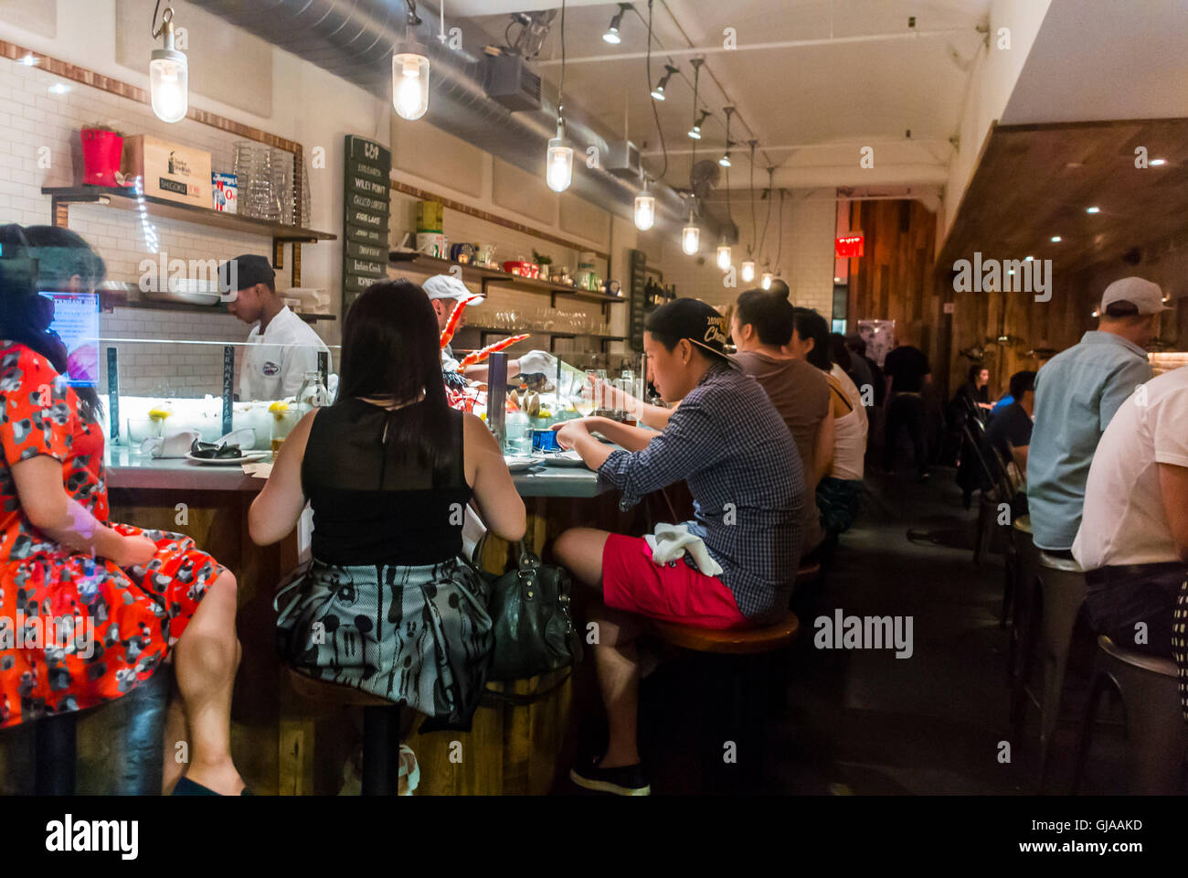 New York City, NY, USA, Large People Chinese Tourists, Sharing Seafood Meals in Restaurant CHelsea Market, man city women sitting counter Stock Photo