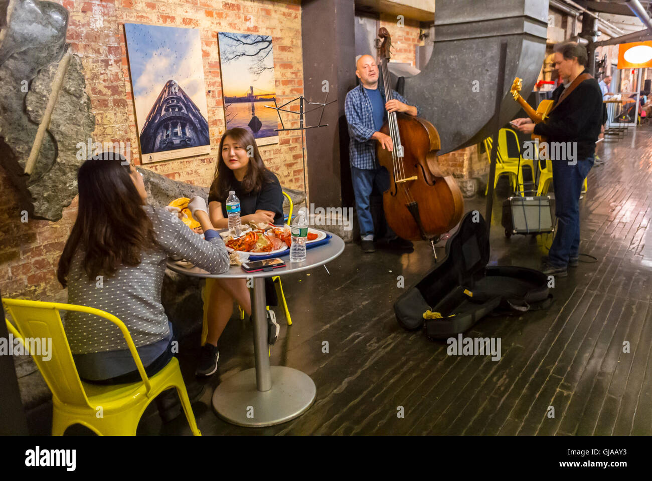 New York City, NY, USA, Chinese Tourists sharing Meals at Table People CHelsea Market, Live Music Performing Stock Photo
