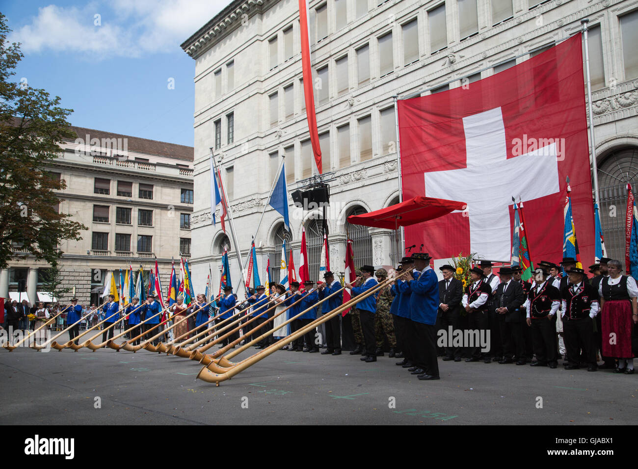 Alphornblasers play alpine horns at a ceremony in Zurich in celebration of Swiss National Day. Stock Photo