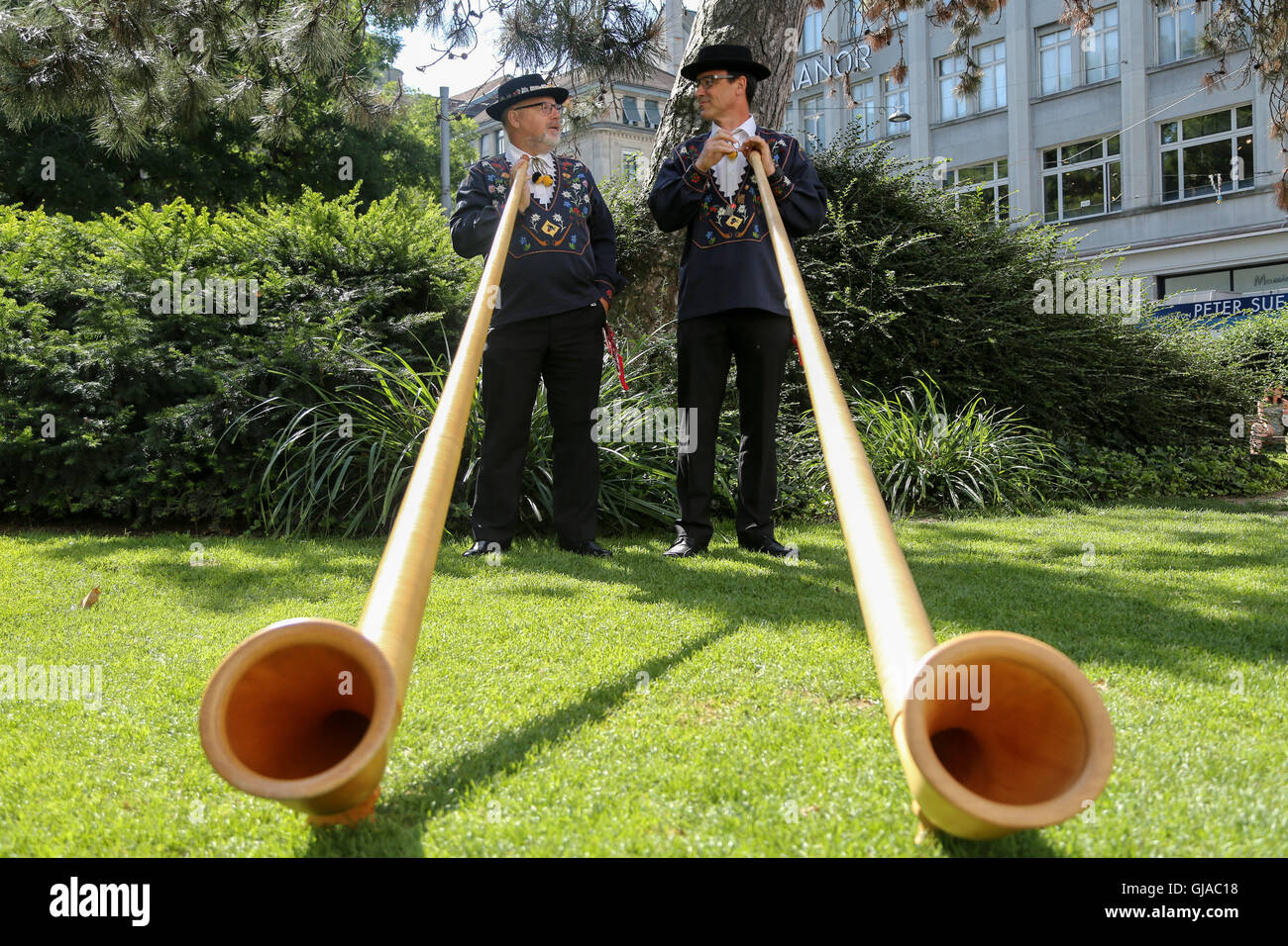 Zurich, Switzland. A pair of alphornblasers perform in Zurich city centre in preparation for Swiss National Day. Stock Photo