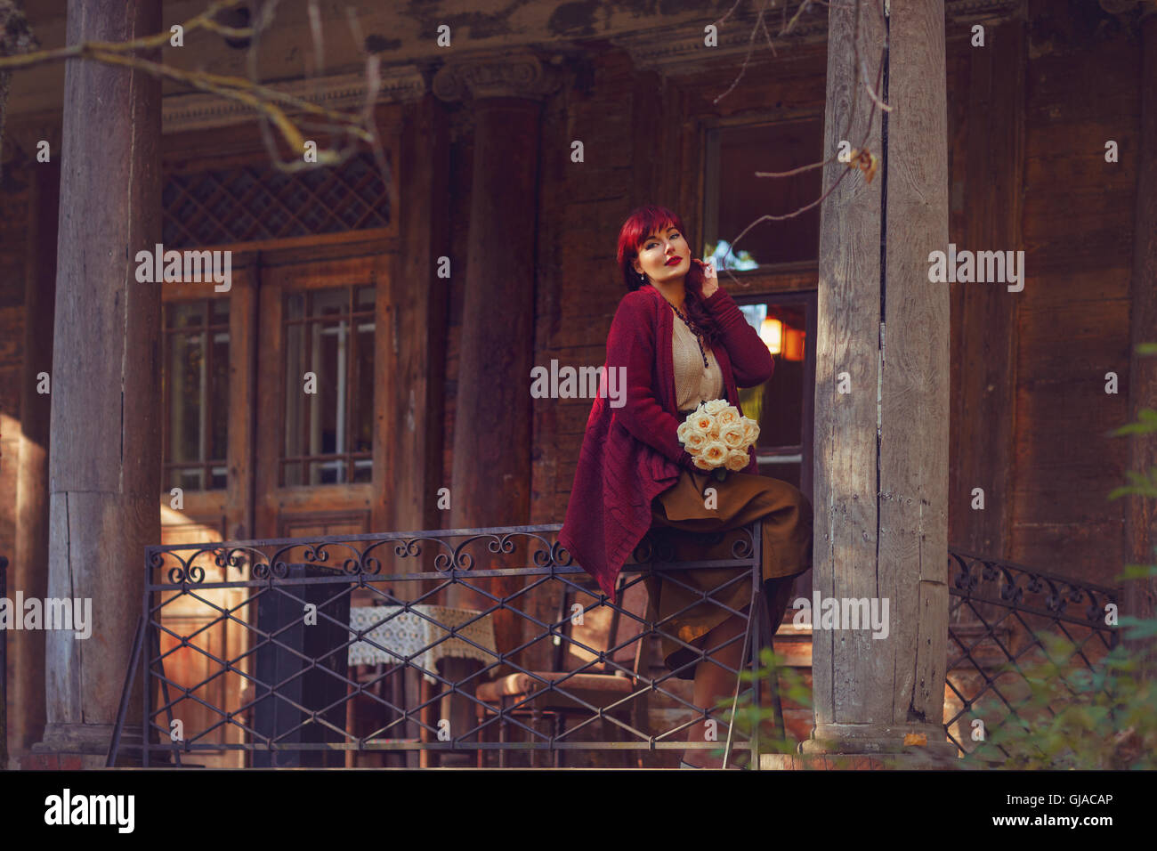 Girl sitting on old house balcony Stock Photo - Alamy