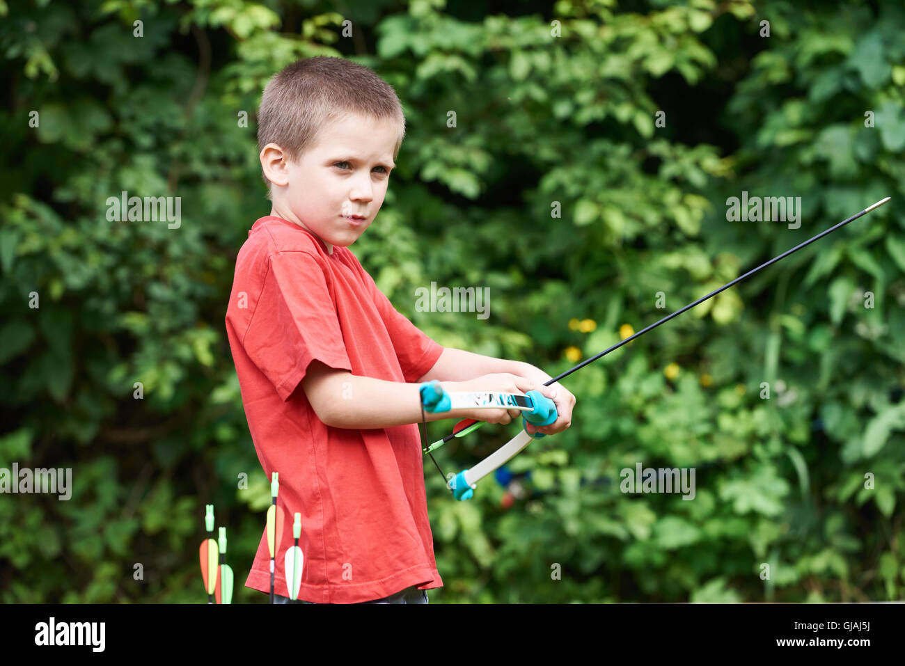 Little archer with bow and arrows outdoors Stock Photo Alamy