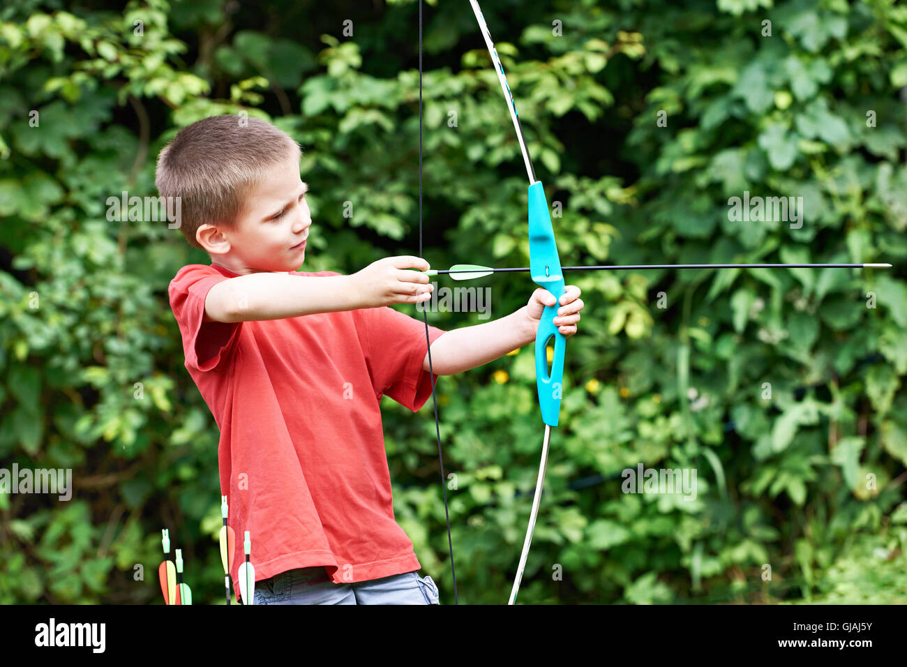 Little archer with bow and arrows outdoors Stock Photo Alamy
