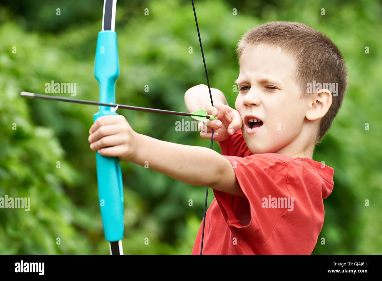 Little archer with bow and arrow outdoors Stock Photo Alamy