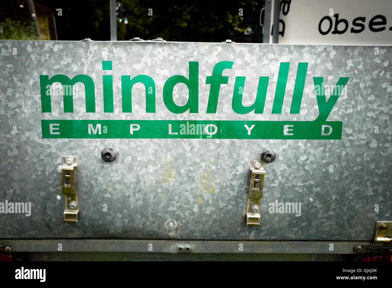 mindfully EMPLOYED sign on a trailer in a community project Stock Photo