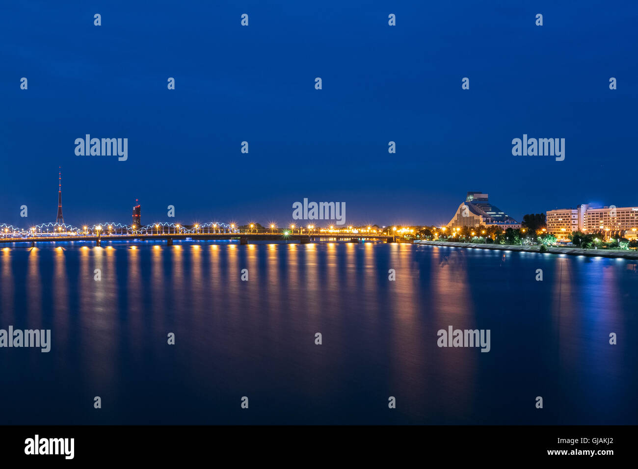 Night Cityscape Of Riga, Latvia. View On The National Library Of Latvia. Riga Radio & Tv Tower. Seafront. Copyspace. Travel Dest Stock Photo