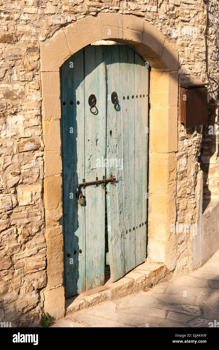 Old blue shabby wooden door with rusty hinges at the entrance of ...