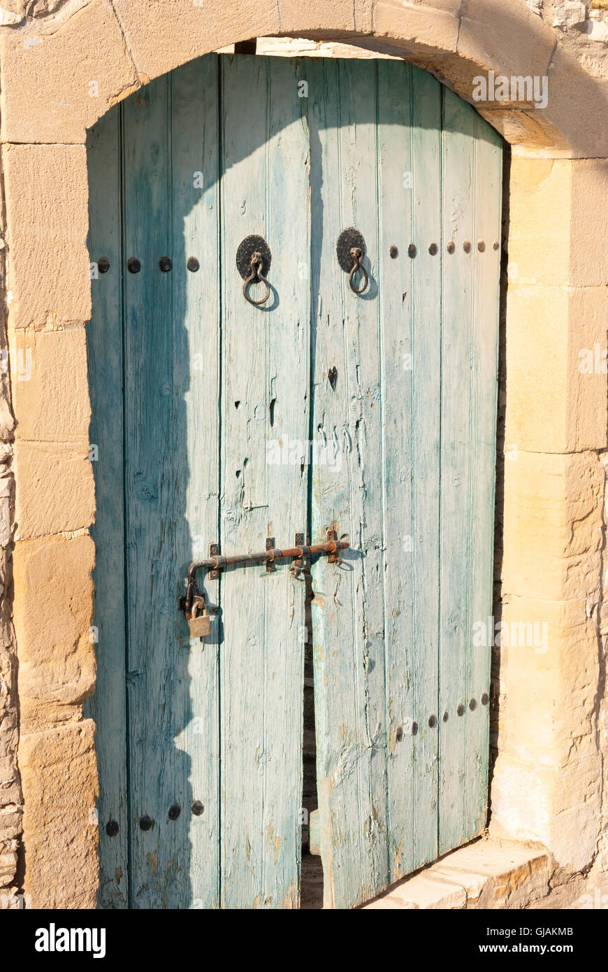 Old blue shabby wooden door with rusty hinges at the entrance of ...