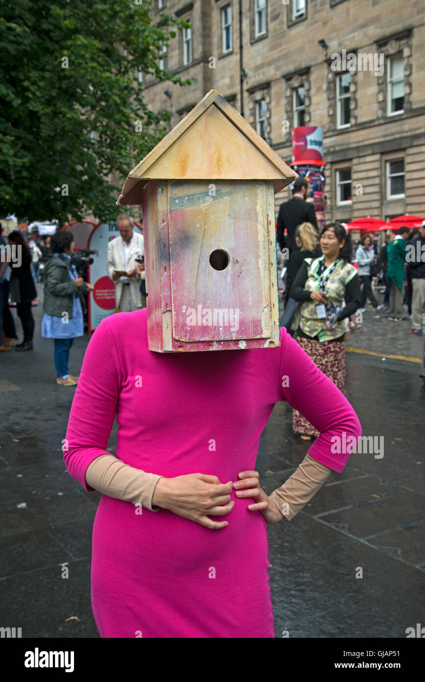 A performer with a birdhouse on her head promotes a show on the Royal Mile during the Edinburgh fringe Festival. Stock Photo