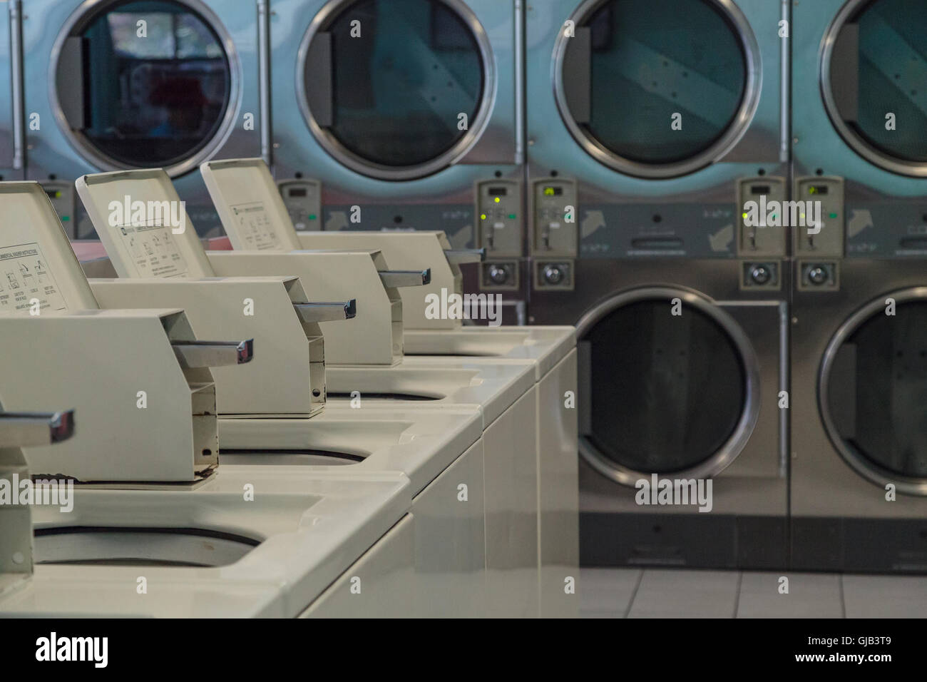 Washing clothes and drying at the Laundromat with chrome washer and