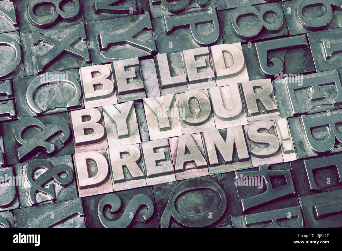 be led by your dreams exclamation made from metallic letterpress blocks with dark letters background Stock Photo