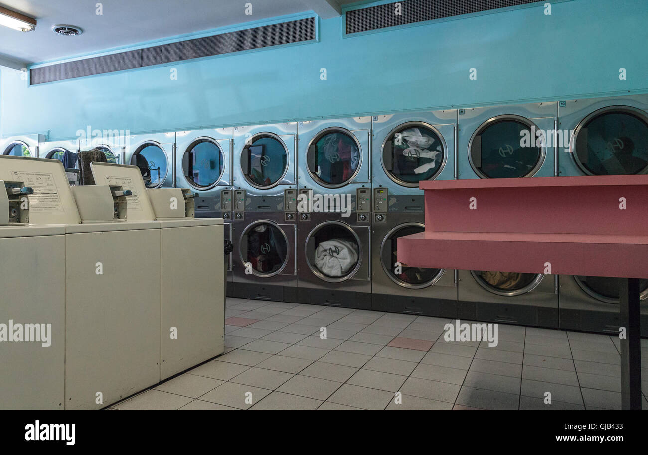 Washing clothes and drying at the Laundromat with chrome washer and