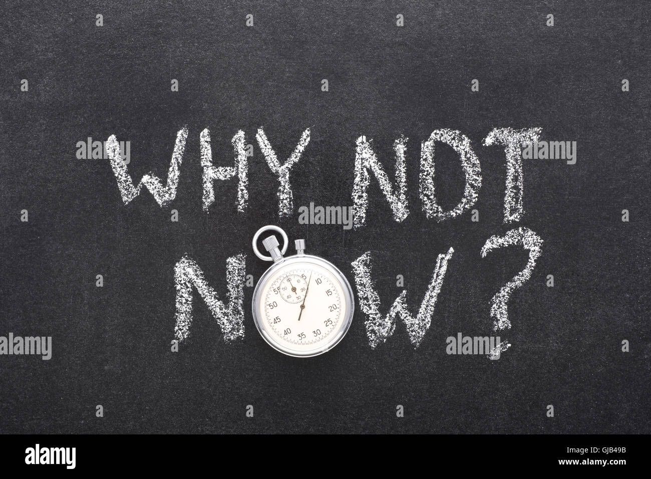 why not now question handwritten on chalkboard with vintage precise stopwatch used instead of O Stock Photo