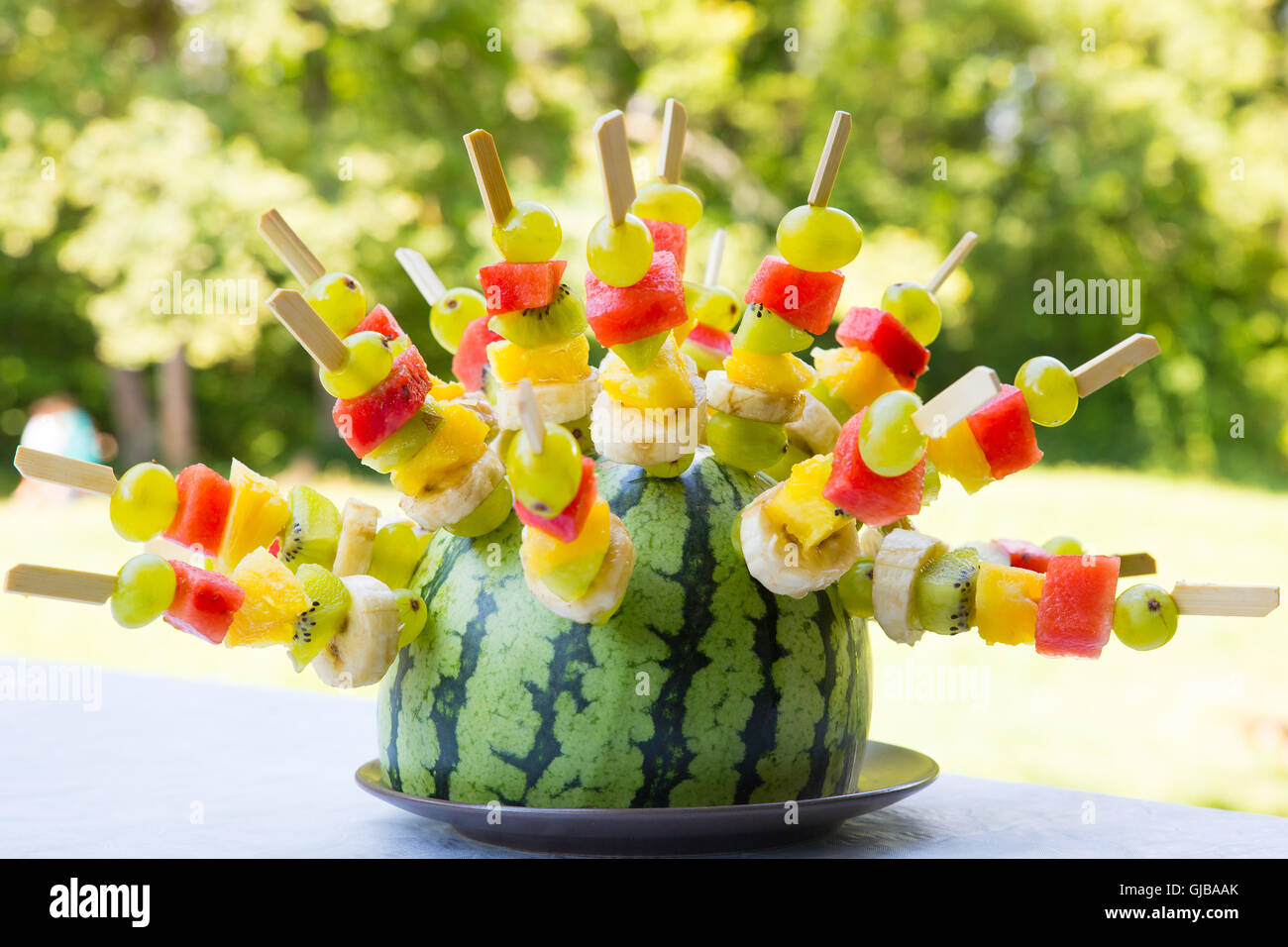 Watermelon decorated with colorful fruit skewers, with shallow depth of