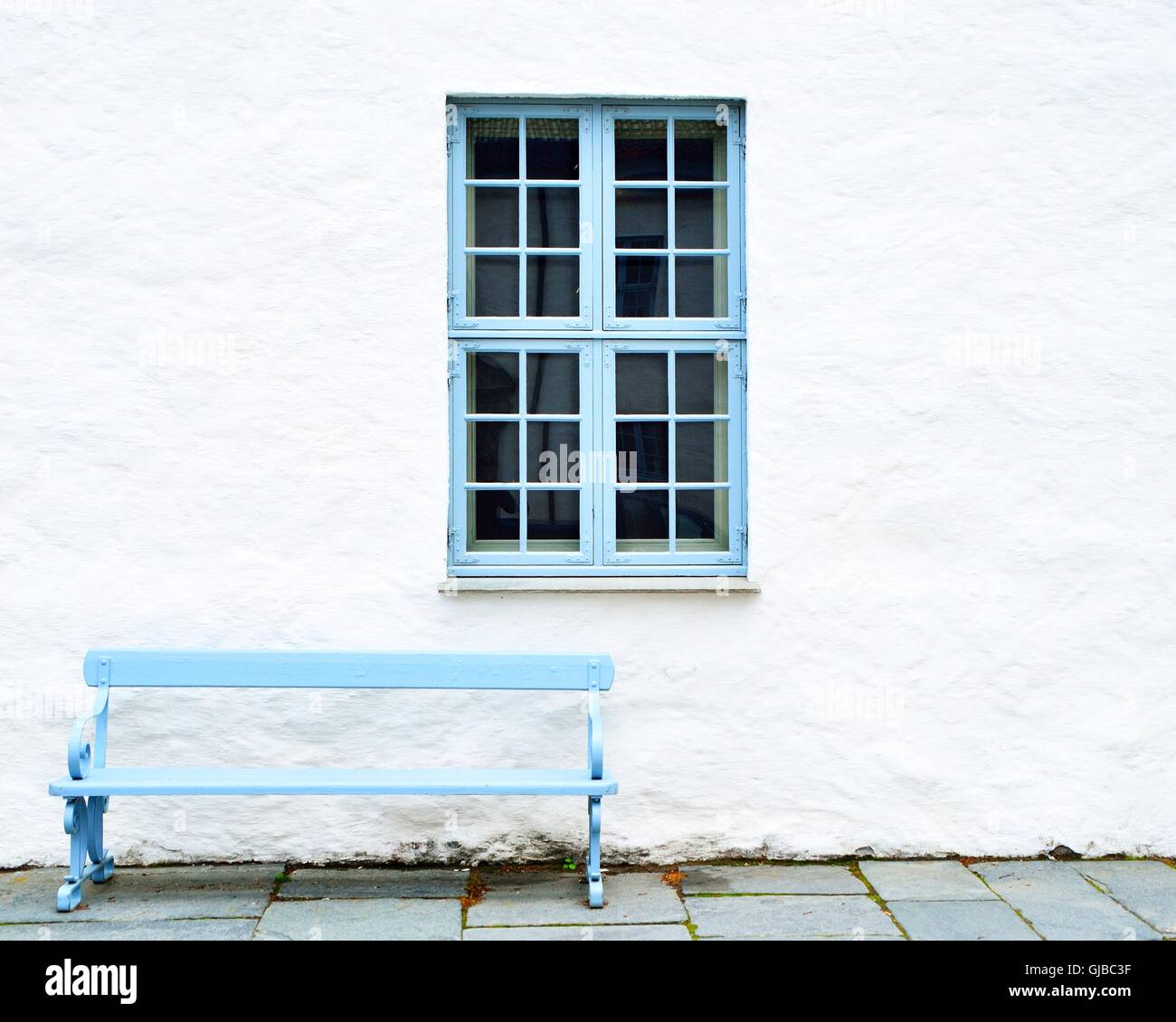 Blue window, blue bench and white wall Stock Photo