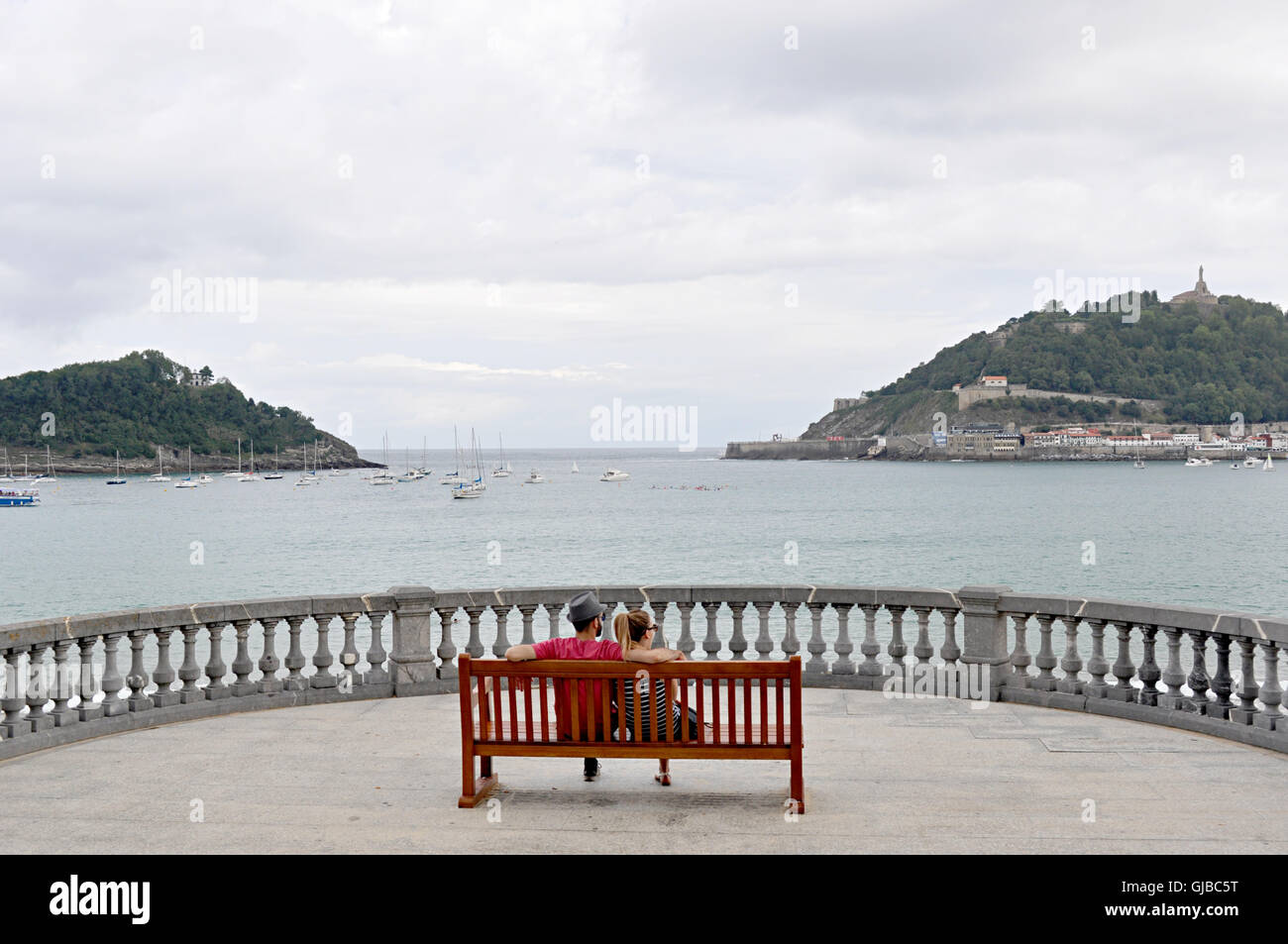 couple watching the sea on a wooden bench Stock Photo - Alamy