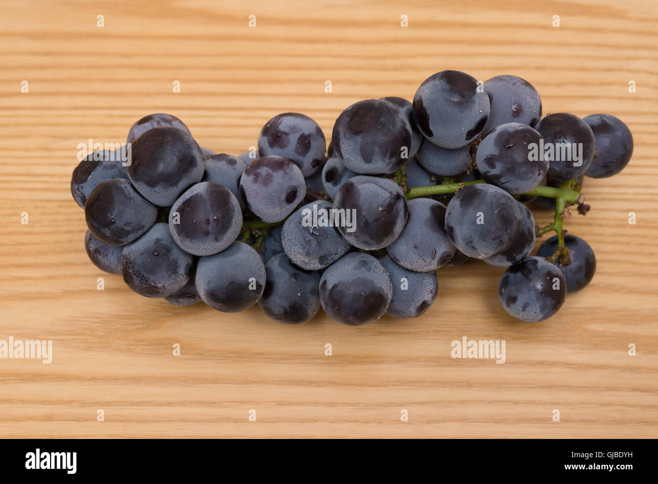 fresh black grapes on a wood table Stock Photo