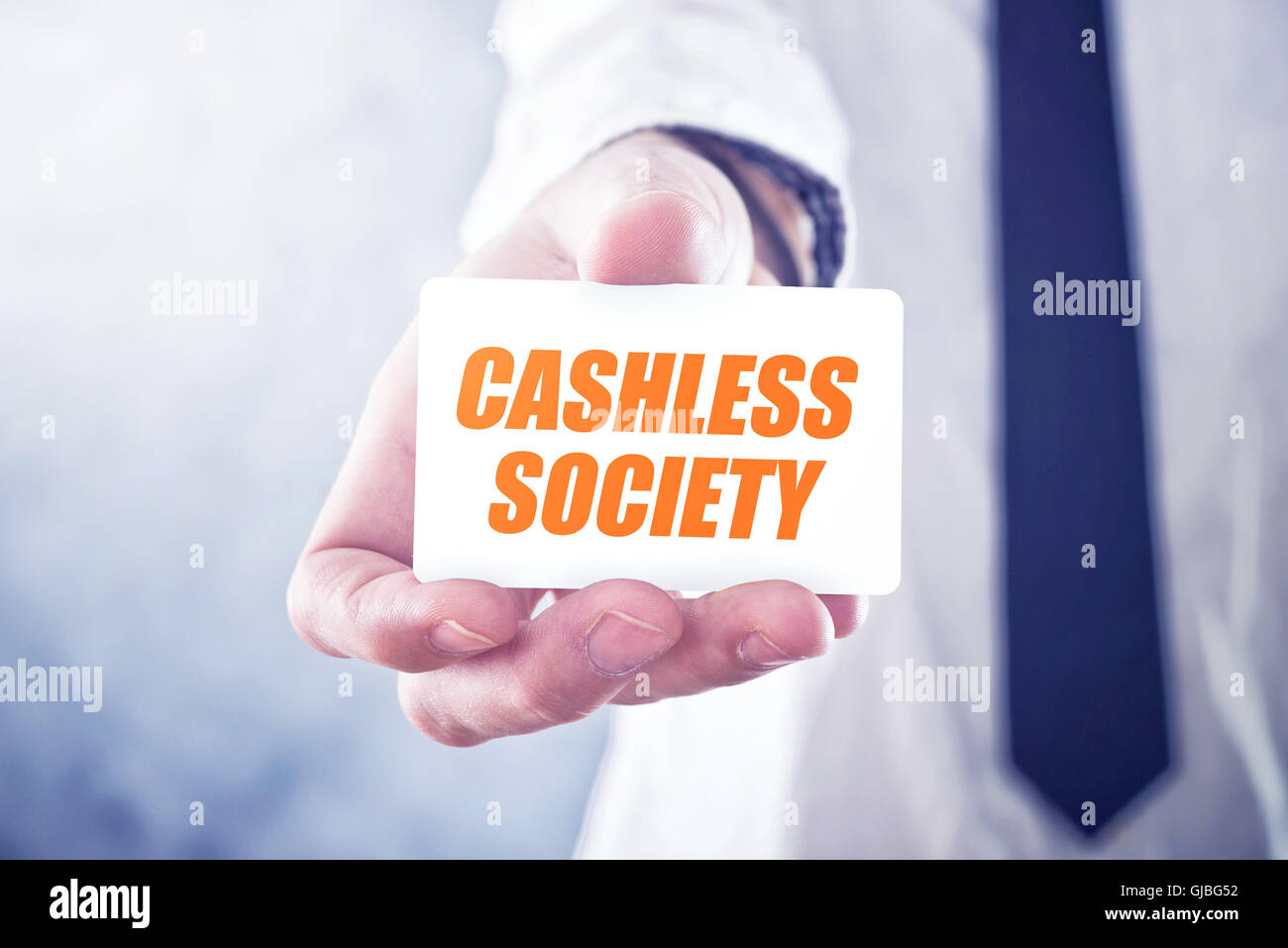 Businessman holding card with Cashless society title, concept of promoting mobile and electronic payments without cash money ban Stock Photo