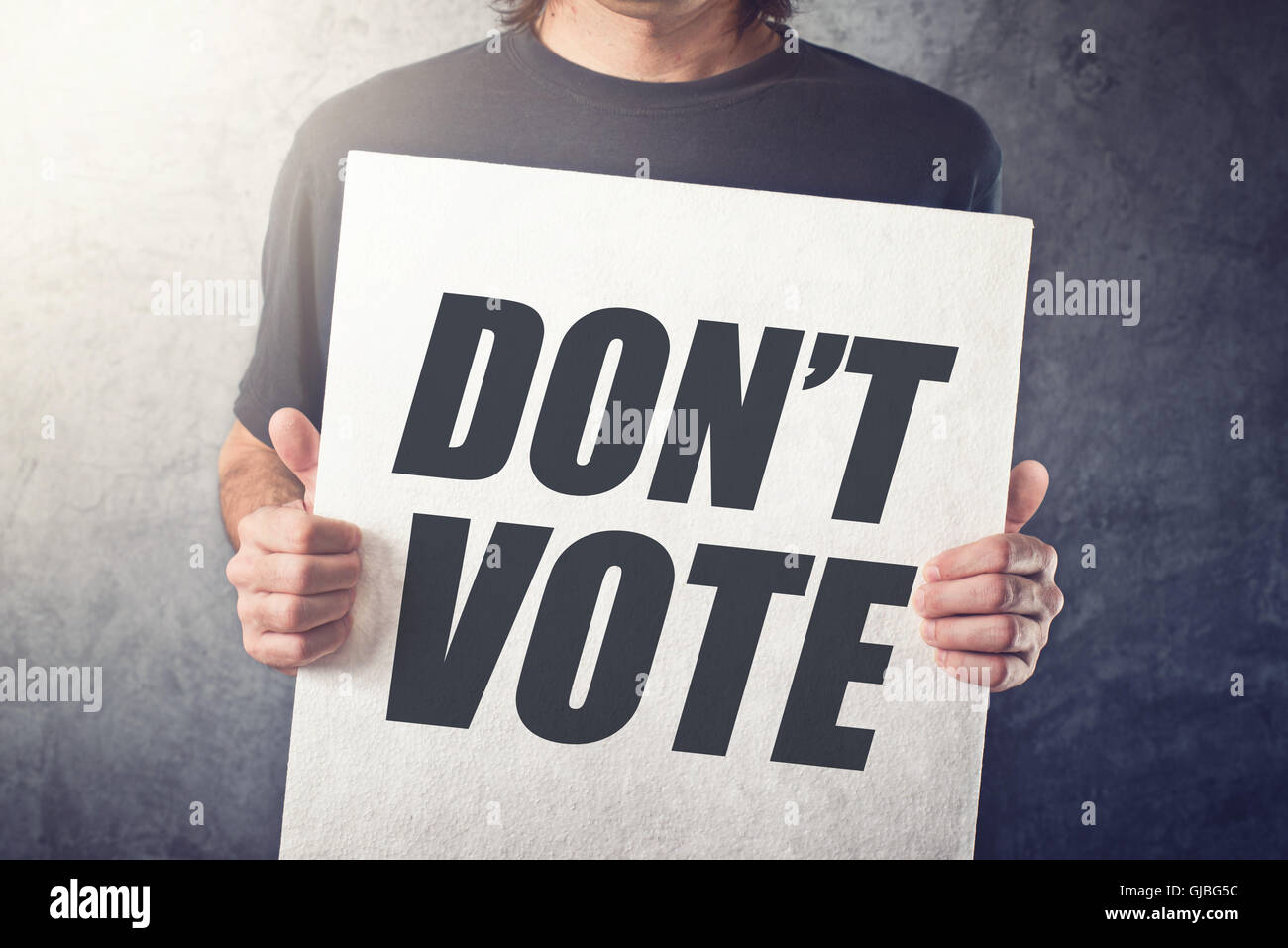 Man holding poster with Don't vote title printed on chest, express attitude and opinion on political elections Stock Photo