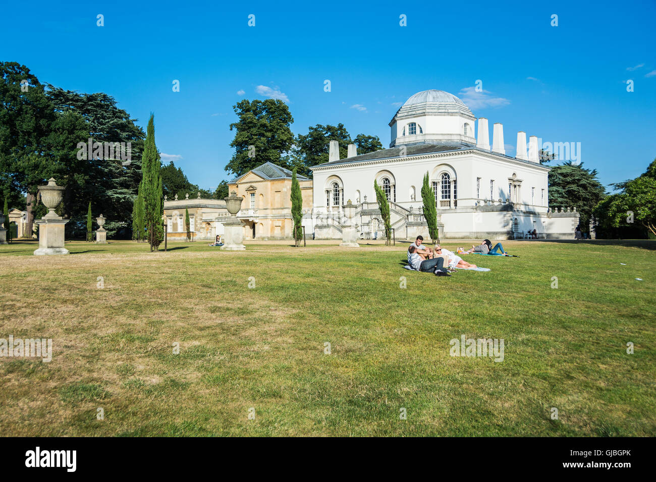 Friends relaxing in the grounds of Chiswick House, an early 18th Palladian villa in Chiswick, London, England, UK Stock Photo