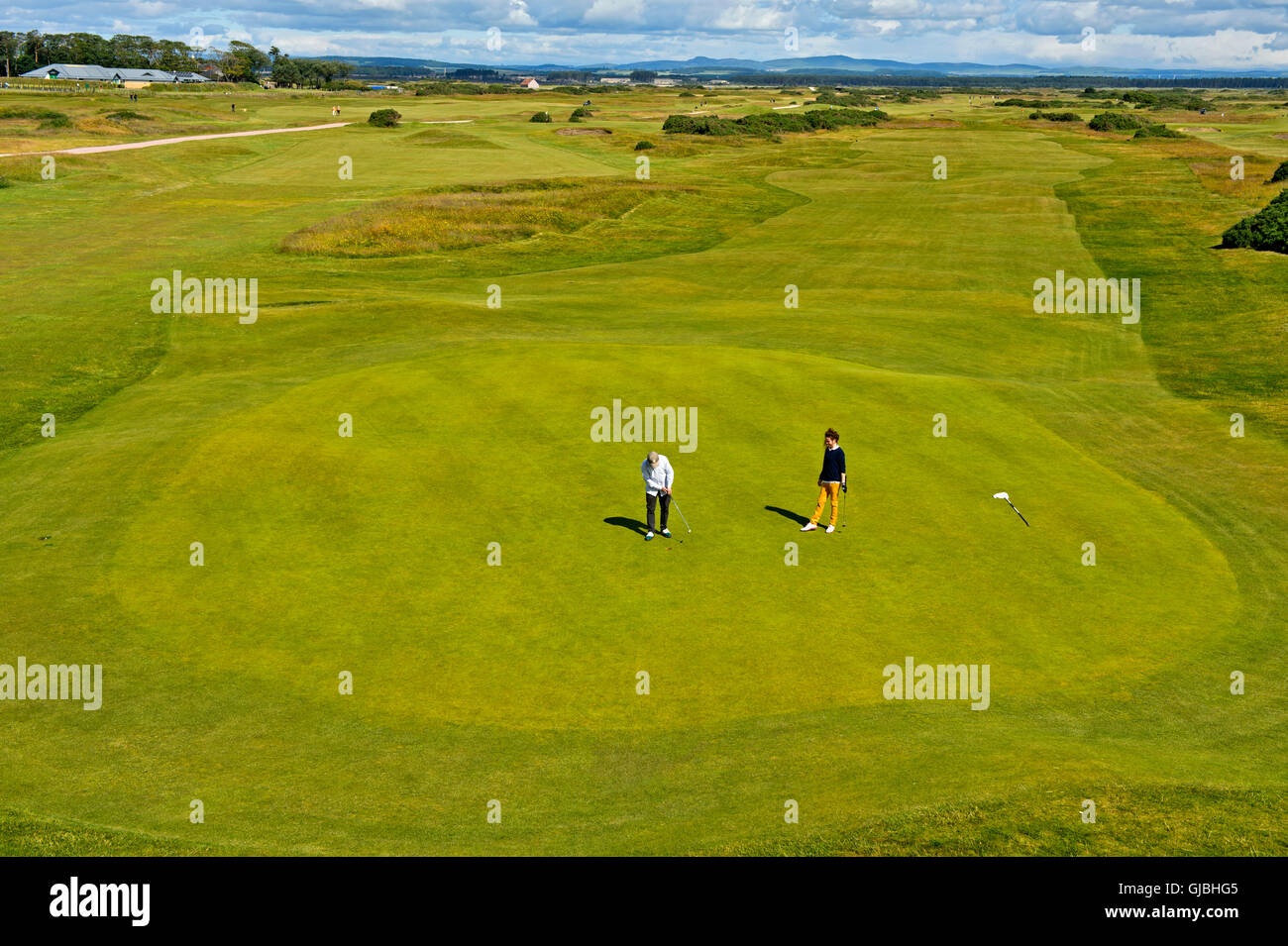 Two golf players on the putting green on a golf course, Golf course St
