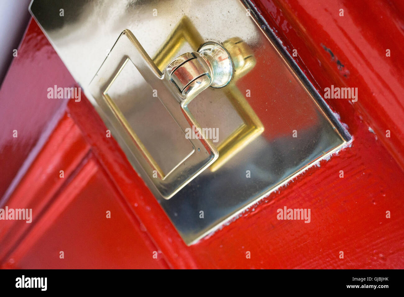Traditional brass door knocker, on a bright red door Stock Photo