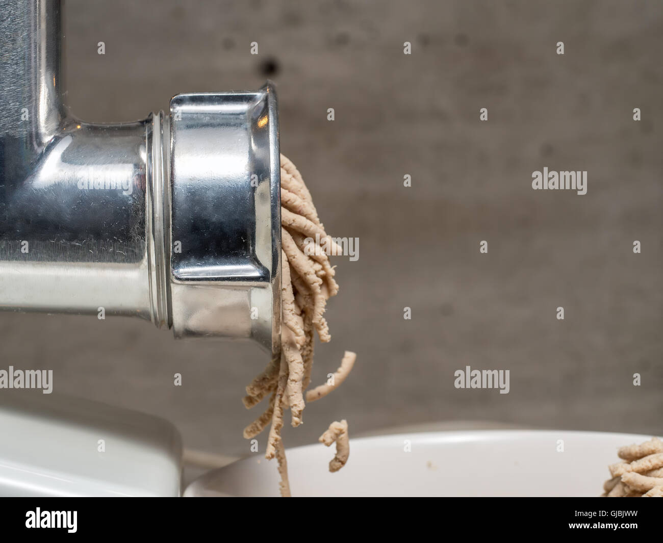 Side shot of grinding machine mincing meat Stock Photo