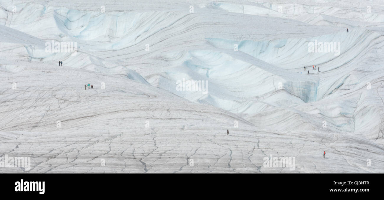 Several groups of people are walking on Root Glacier Stock Photo