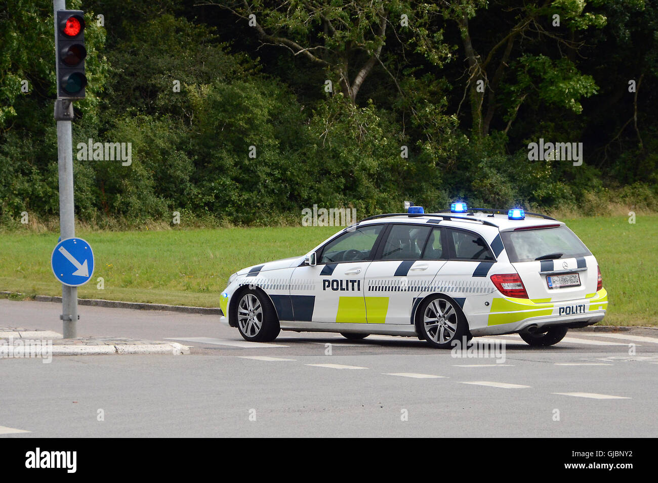 Danish Police car with blue light takes sharp corner at red light. Pic labeled dig. altered, only because license plate blurred Stock Photo