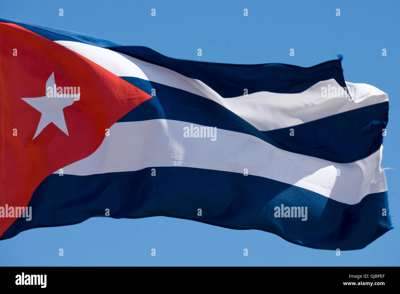 The Cuban flag flying against a bright blue sky. Stock Photo