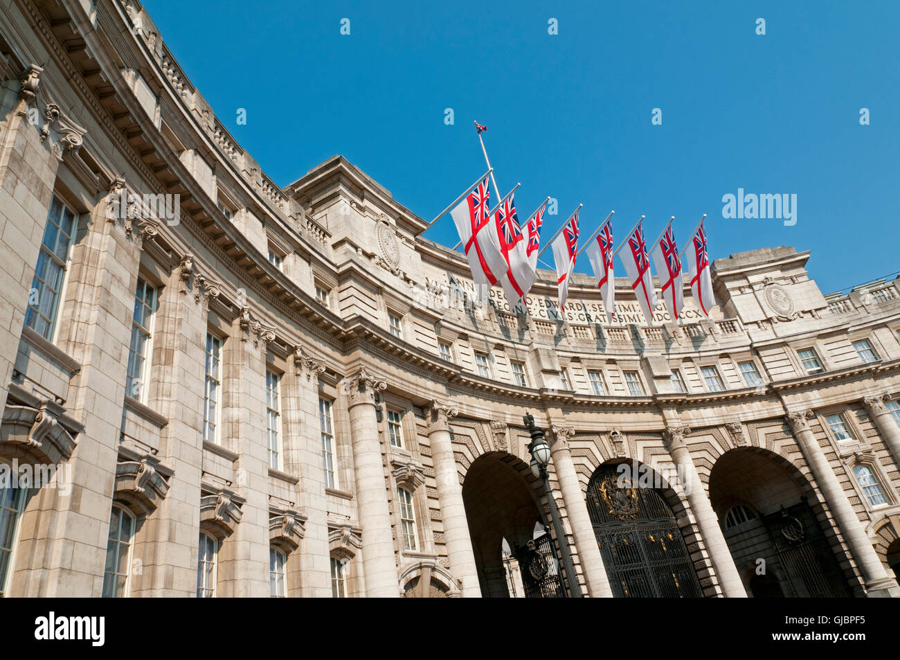 Admiralty Arch in London with eight white ensigns, the flag of the British Royal Navy, flying. Stock Photo
