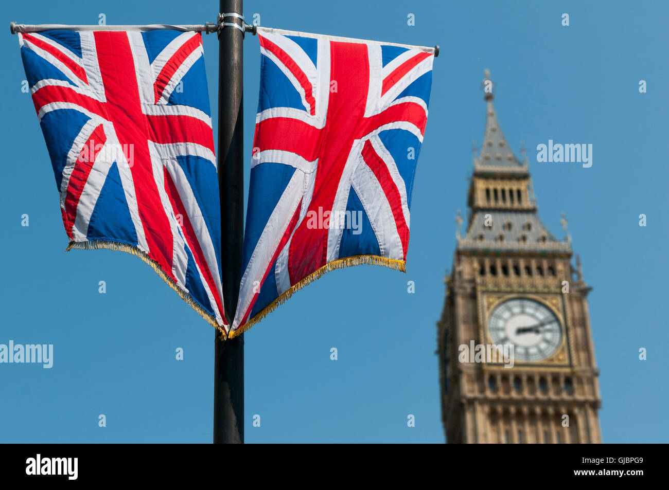 The Union Jack flag flying in front of the clock tower, commonly referred to as Big Ben, of the Palace of Westminster. Stock Photo
