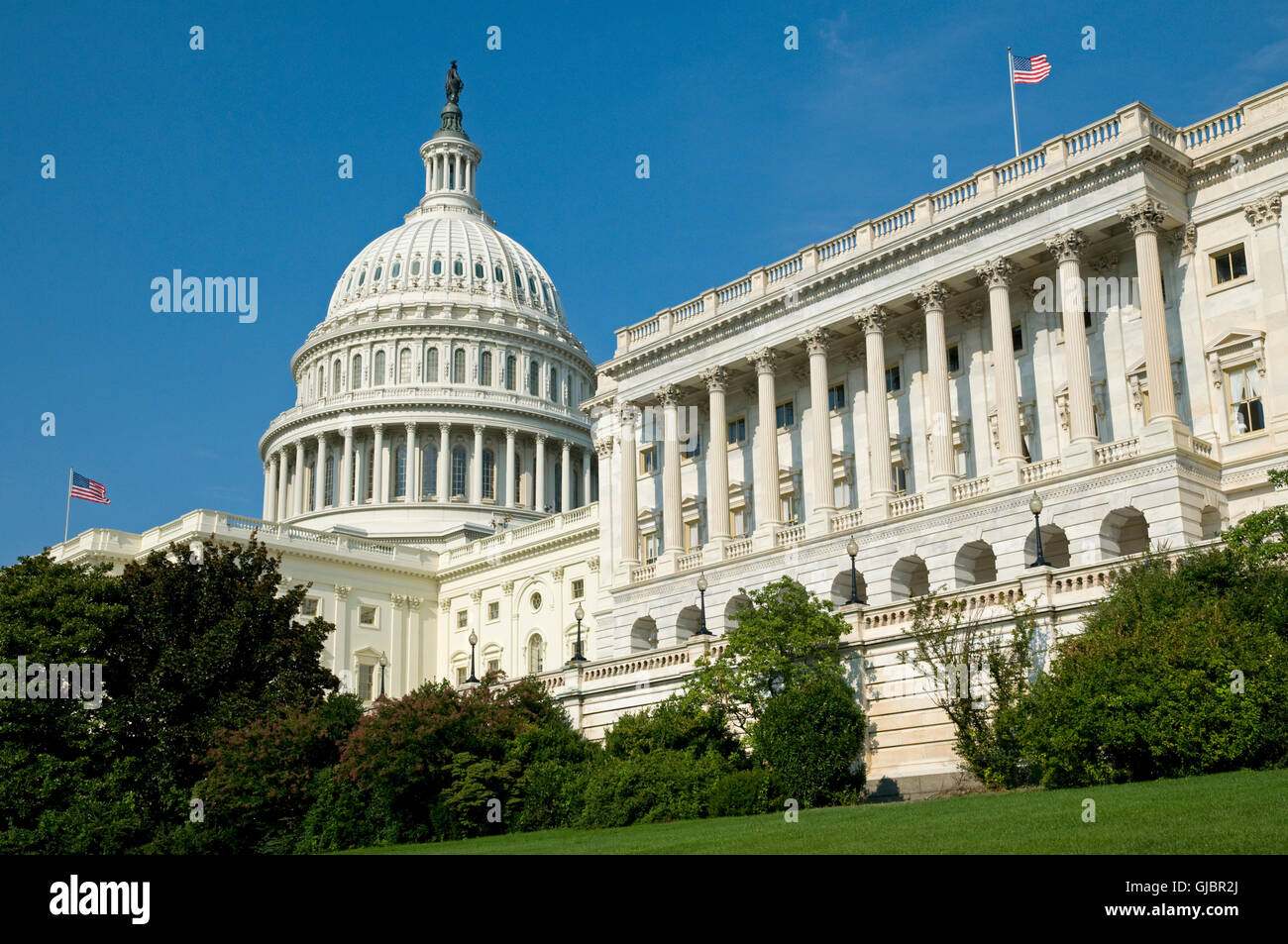 The US Capitol Building where the House of Representatives is in session under the flag flying on the right. Stock Photo