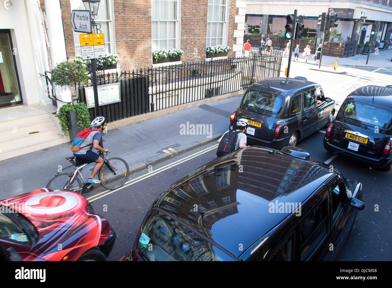 Black cabs in Marble Arch W1 road in central London passing Great Cumberland Place in the Westminster Borough Stock Photo