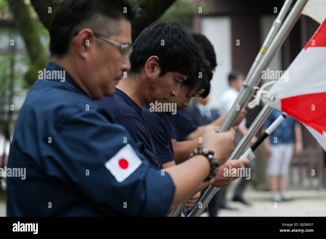 Tokyo, Japan. 15th Aug, 2016. Japanese nationalists dressed in military uniform hold flags to pay their respects to the war dead at Yasukuni Shrine on the 71st anniversary of Japan's surrender in World War II on August 15, 2016, Tokyo, Japan. Some 70 lawmakers visited the Shrine to pay their respects, but the Prime Minister Shinzo Abe did not visit the controversial symbol and instead sent a ritual offering to a shrine. Credit:  Aflo Co. Ltd./Alamy Live News Stock Photo